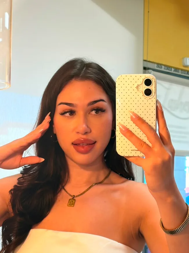 Client taking a mirror selfie after her lash appointment
